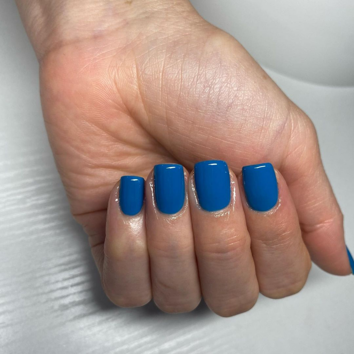 Hand with blue nails wearing DND #437 gel polish