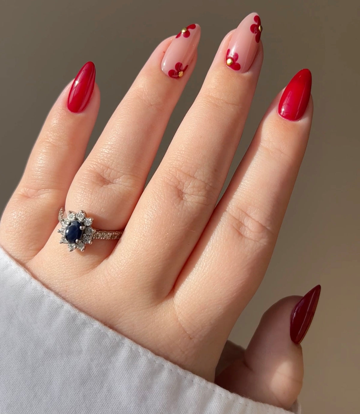 Hand with glossy coral-red nails