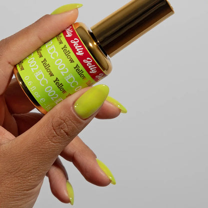 Hand with yellow jelly manicure holding a bottle of DC Jelly Yellow gel nail polish