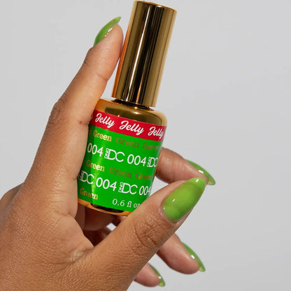 Hand with green jelly manicure holding a bottle of DC Jelly Green gel nail polish