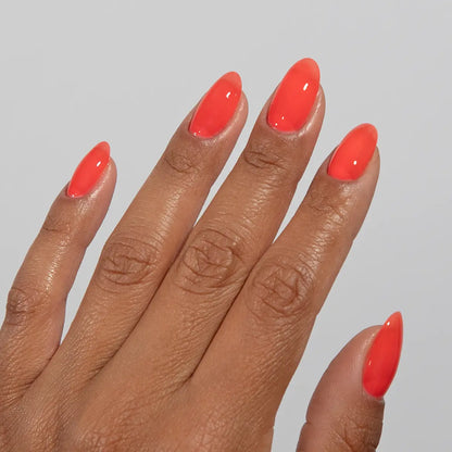 Hand with long almond nails wearing DC Jelly Poppy vibrant coral orange jelly nail polish