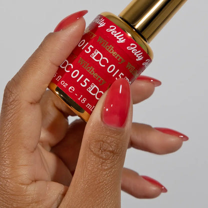 Hand with red jelly manicure holding a bottle of DC Jelly Wildberry gel nail polish