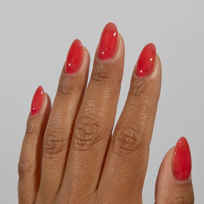 Hand with long almond nails wearing glossy DC Jelly Wildberry red jelly gel nail polish