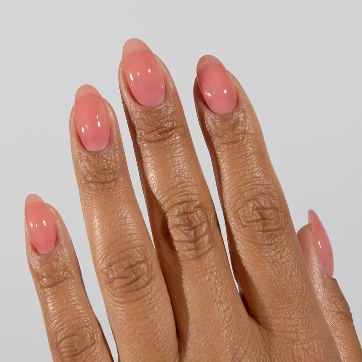 Hand with long almond nails wearing DC Jelly Rose dusty pink jelly nail polish