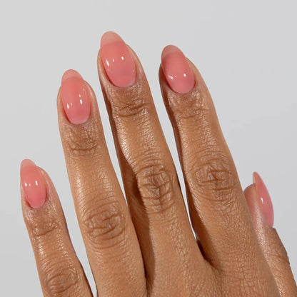 Hand with long almond nails wearing DC Jelly Rose dusty pink jelly nail polish