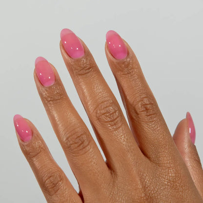 Hand with long almond nails wearing DC Jelly Orchid bright pink-purple jelly nail polish