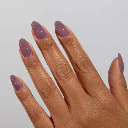Hand with long almond nails wearing DC Jelly Plum Haze muted purple jelly nail polish