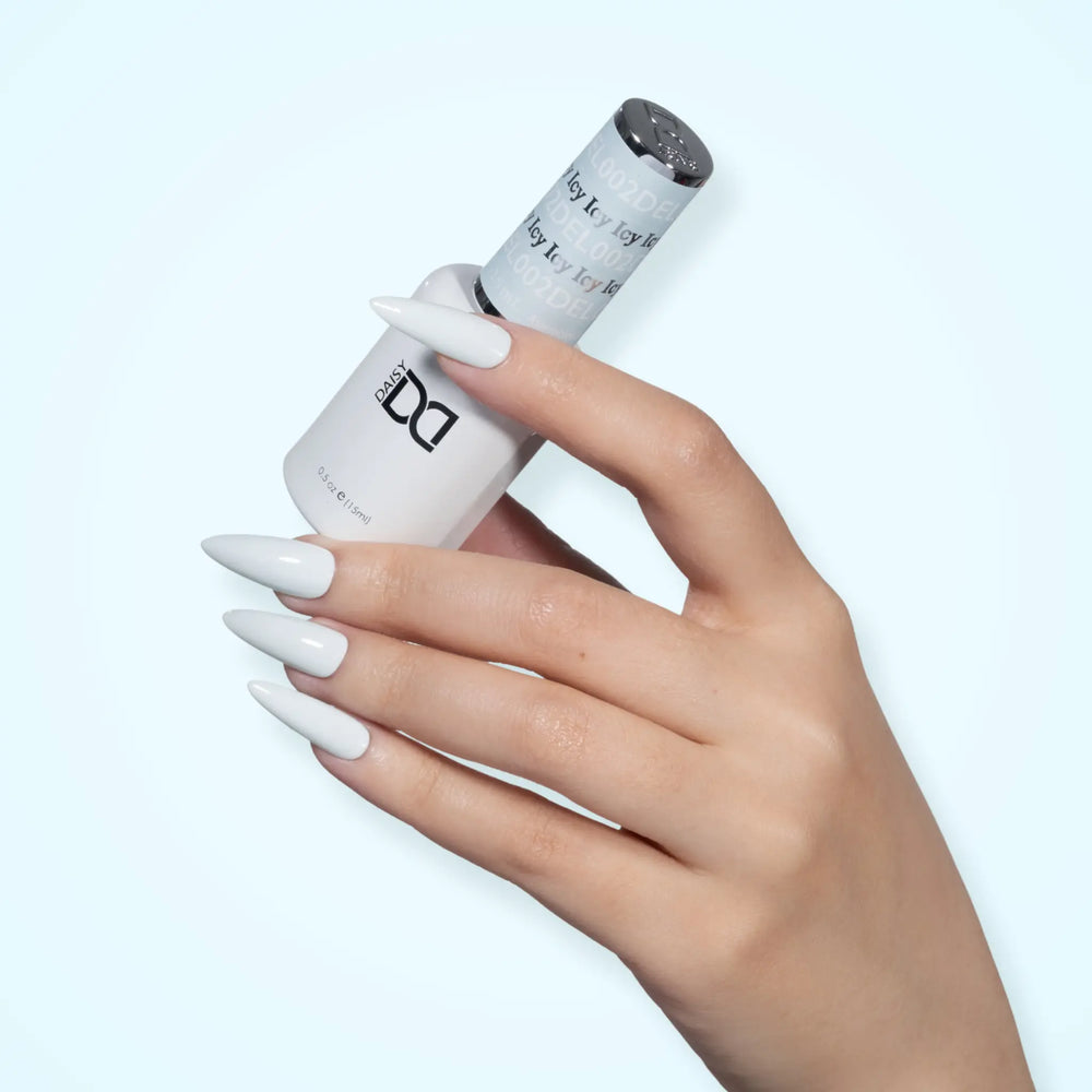 Hand with glossy white nails holding a DND DEL #002 Icy gel polish bottle