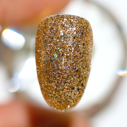 Swatch of Golden Sahara Star on a medium almond nail showing gold glitter with specks of silver holographic glitter