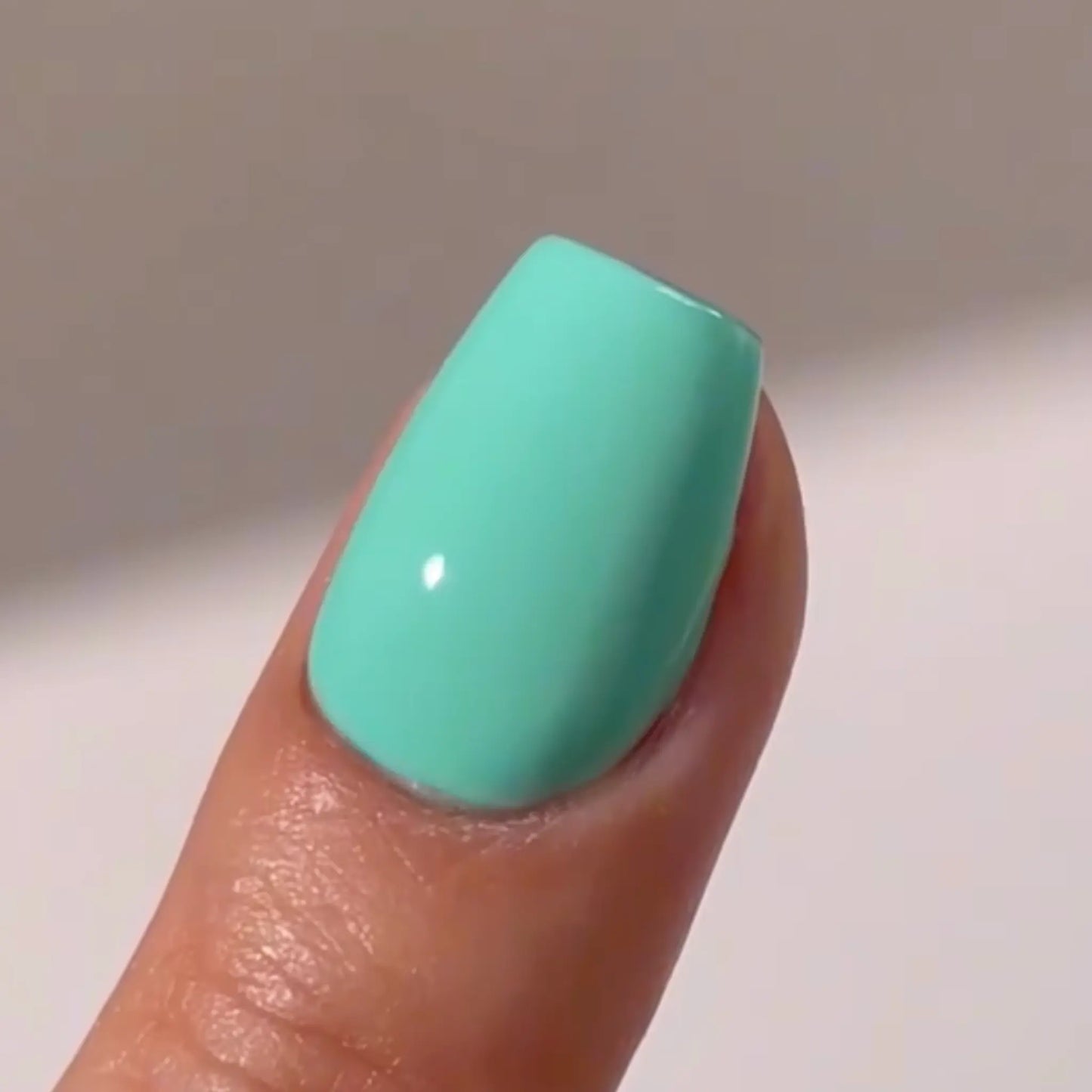 Close-up of an extra-short coffin nail in mint green, DND #787 Carousel
