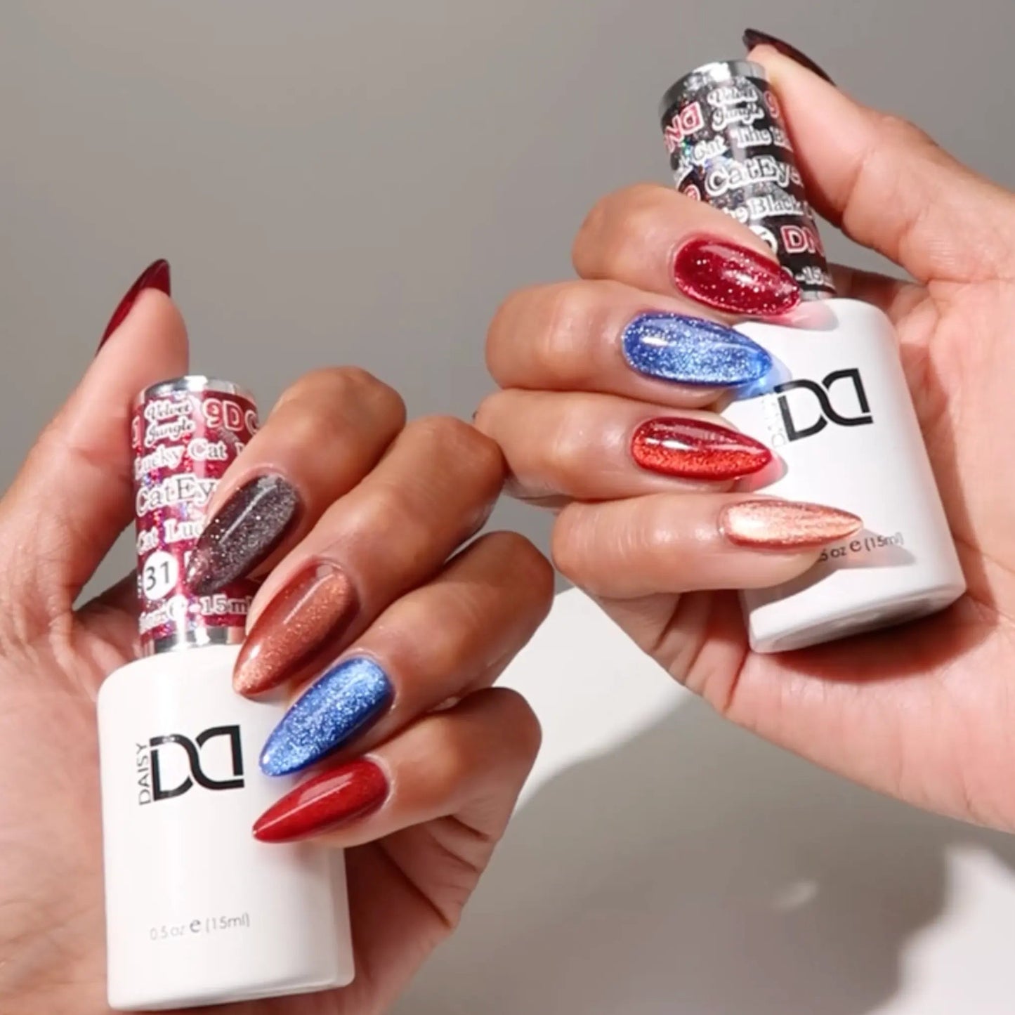 Hands with medium almond nails wearing cat eye nail polishes and holding DND gel bottles