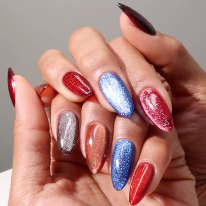 Close-up of two hands with variously colored cat eye gel nail polish on a neutral background