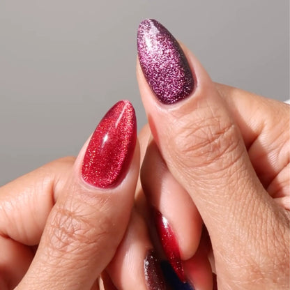 Fingers with medium almond nails wearing the red and purple cat eye nail polish with magnetic effects