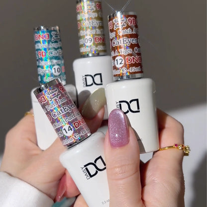 Hand holding cat eye nail polish bottles with blue, orange, yellow, and pink colorful labels with a glittery finish