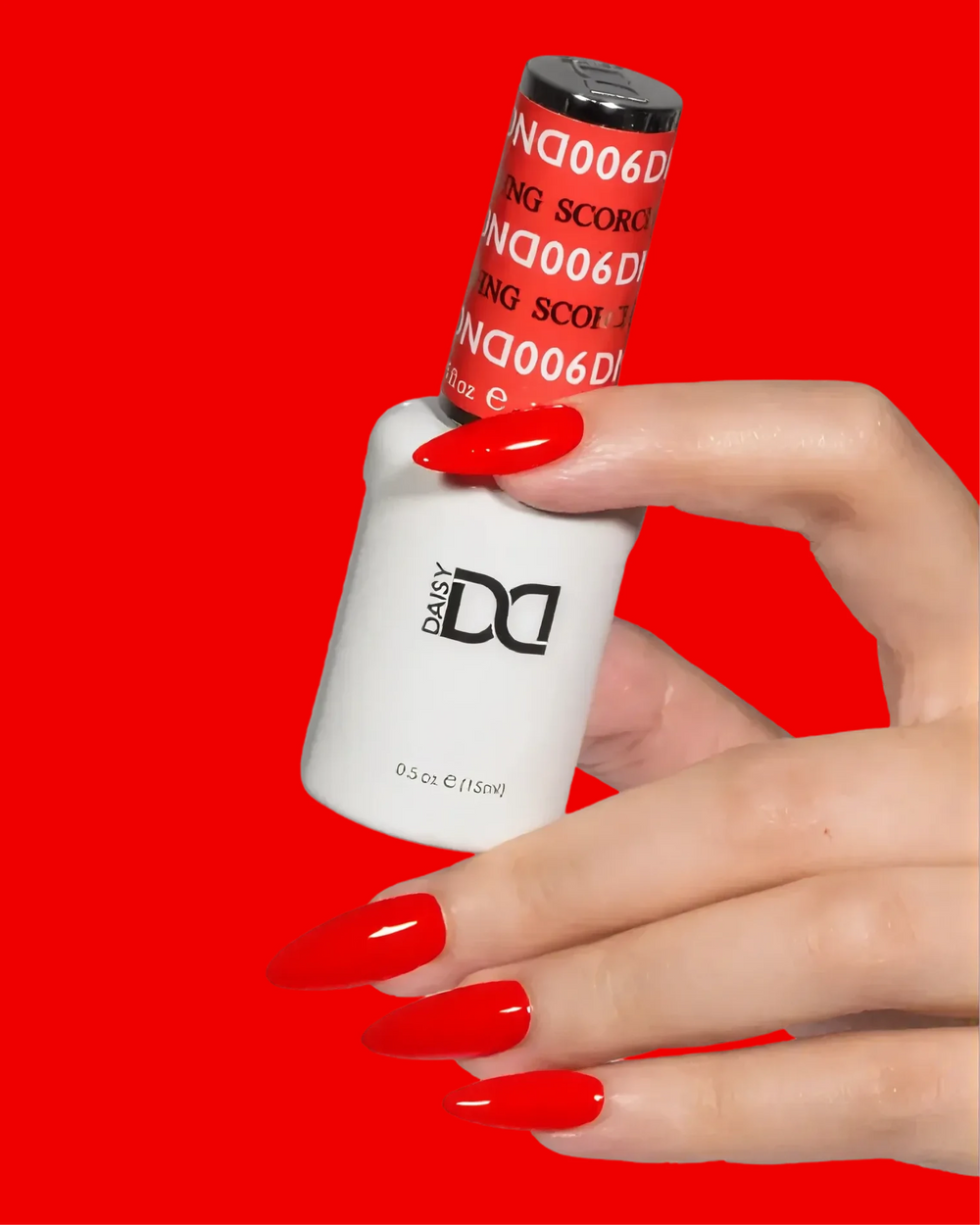 Hand with bright red nails holding a red DND gel polish bottle