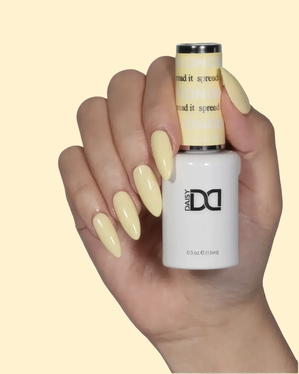 Hand with pale yellow nails holding a DND gel polish bottle labeled "Spread It"
