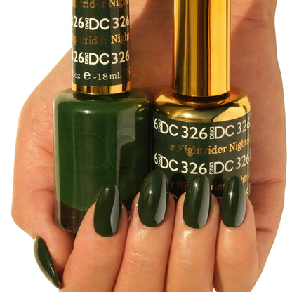 Hand holding two bottles of DC Nightrider #326 gel nail polish, dark forest green, with matching glossy manicured nails